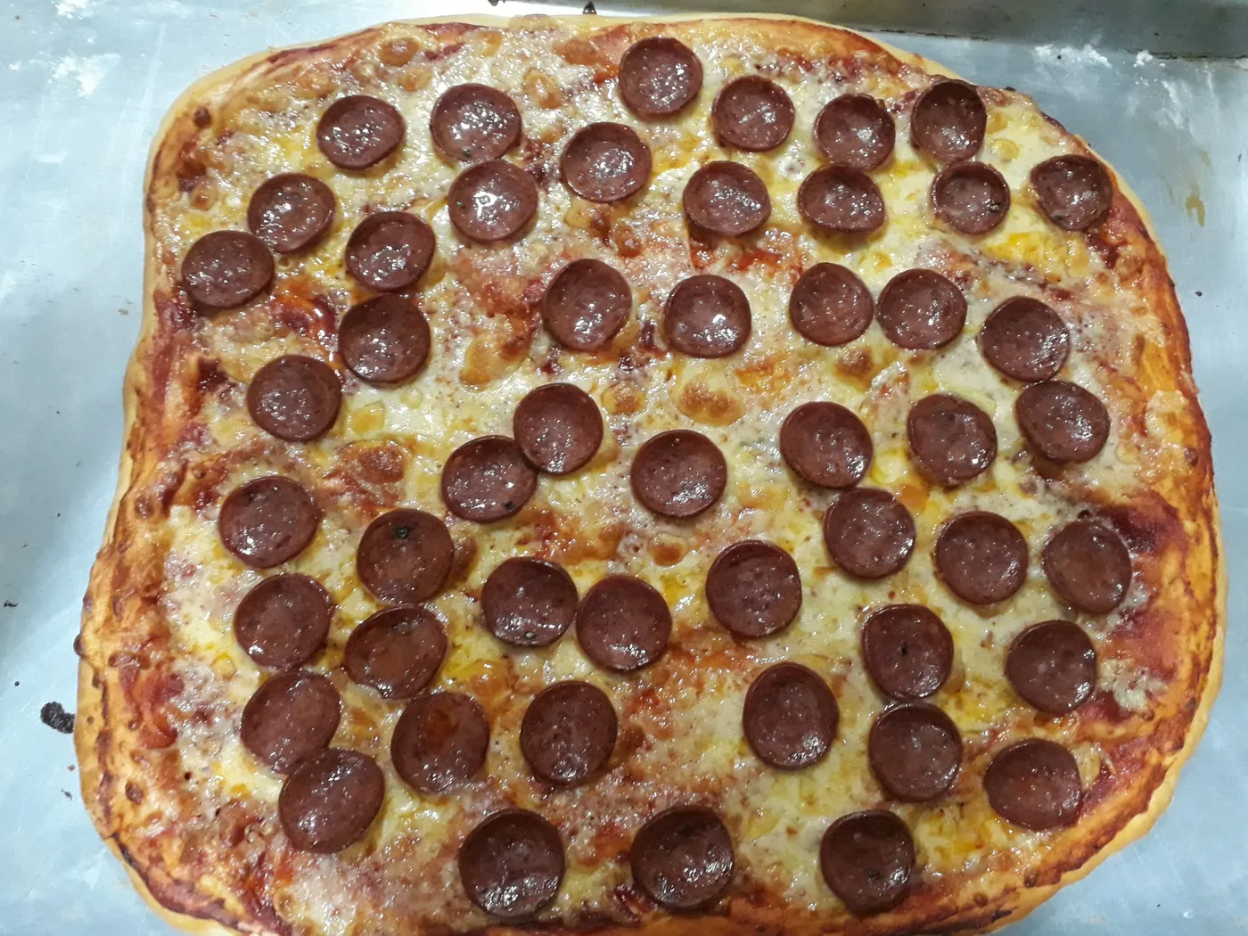 Pizza de pepperoni recién horneada, con queso gratinado y rodajas de pepperoni