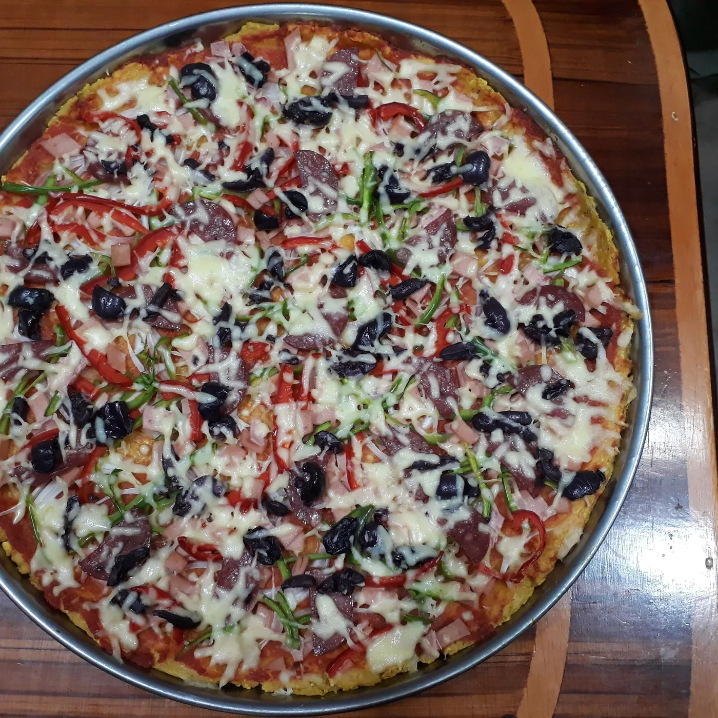 Pizza The Works entera con aceitunas negras, pimientos, jamón y queso, vista desde arriba