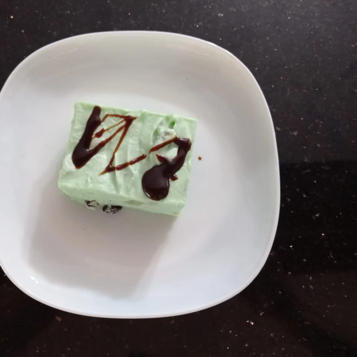 Mousse de limón con hilos de chocolate en plato cuadrado
